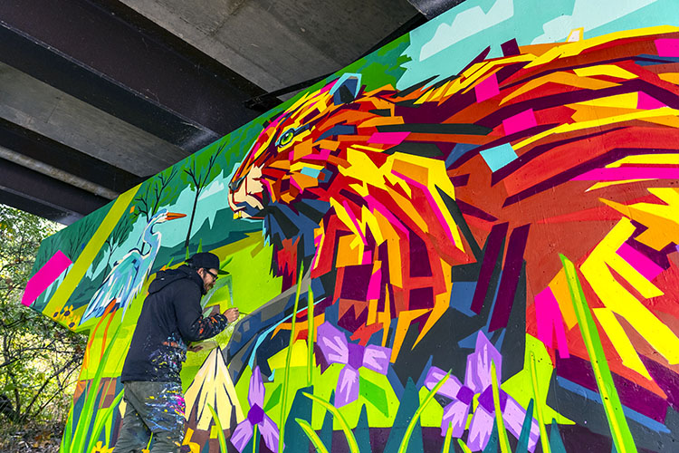 Arlin Graff painting the mural